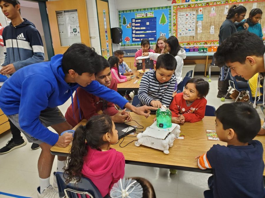Freshman Rusheel Nadipally and freshman Dhruv Khatod demonstrate circuits and electrical components to eager elementary school students.