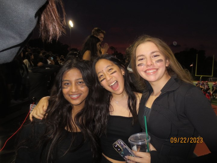 Trying to go out in with a bang, seniors Nabeeha Areeba, Lauren Hwang and Lauren Woody pose during the Blackout Homecoming game. “That was our last high school Homecoming game, so we went all out and it was really fun,” Hwang said.