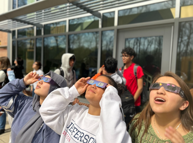 Using+the+provided+solar+eclipse+glasses+to+protect+their+eyes%2C+sophomores+Saadia+Anwaryan%2C+Tori+Isidro+and+Kimberly+Cruz-Cruz+look+up+at+the+eclipse.+%E2%80%9CI+loved+watching+the+eclipse+because+it+reminds+us+that+even+when+we%E2%80%99re+everywhere+in+the+world%2C+we+are+some+of+the+smallest+bits+that+make+up+such+a+big+universe%2C%E2%80%9D+Cruz-Cruz+said.+