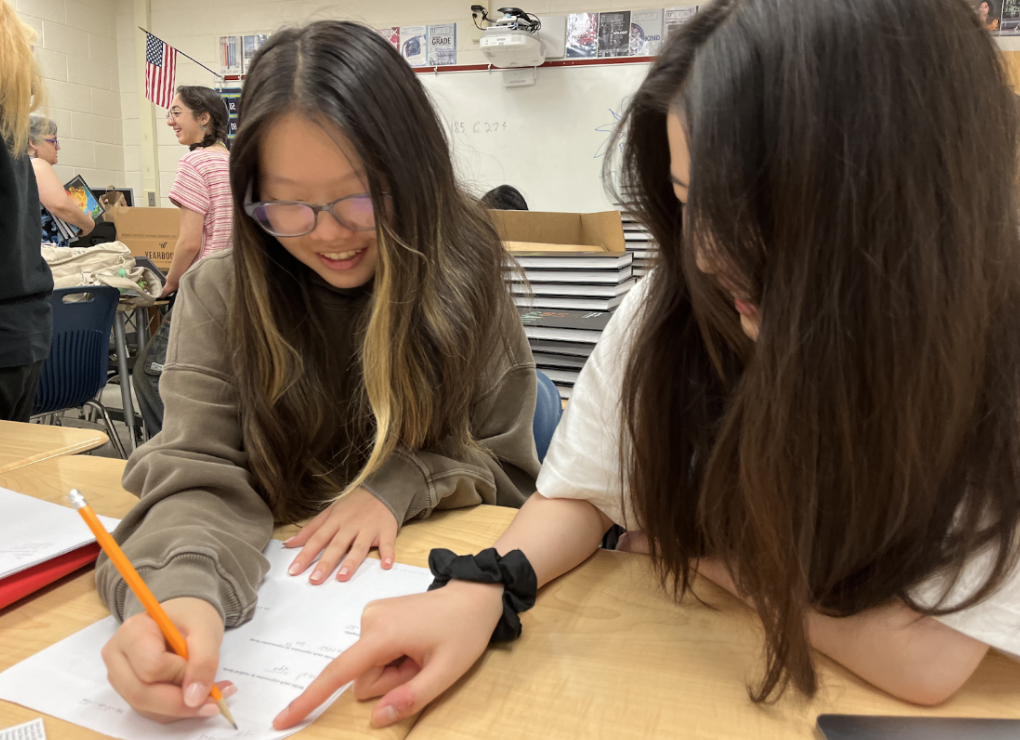 Working together, Chloe Hong and Caroline Chu collaborate on math. By working together, they are able to find the solution to problems quickly, and they also like using this strategy on group tests. “I flip through until I come across a question I’m not confident on, and then I’ll consult the other group, since we don’t want to waste the time given to us,” Hong said.