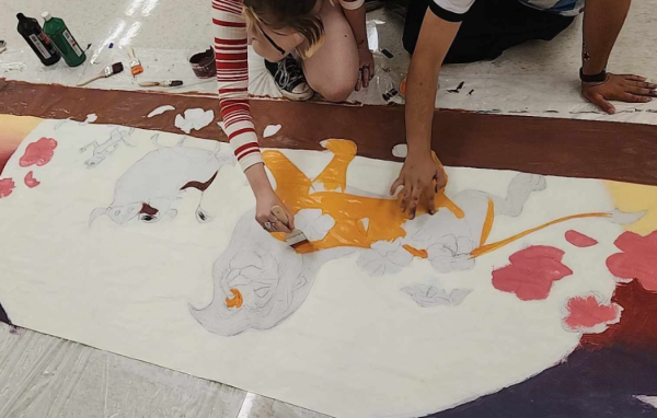 Seniors Dani Hunter and Lux Robles paint Simba for the Class of 2025 banner, following 2025's Homecoming theme of the year: "Hakuna Matata." “We first started out by blocking out the colors, then painting over it,” Hunter said. 