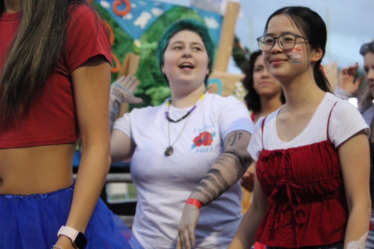 Junior Ami Le walks next to her class float during the Homecoming football game. “After finishing [construction on] the whole [float], we loaded it onto a truck that we rented, and then our sponsor, Mr. Sarmiento just drove it around,” Le said. 