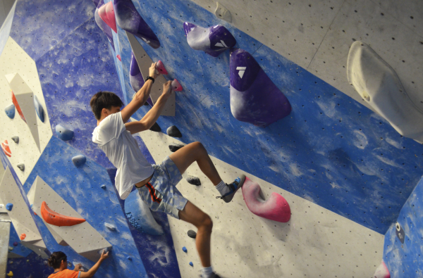 Sophomore Alan Lam boulders the edge of a wall during the climbing session on Sept. 4, the second session that he has attended. “The community here is really great because everybody knows each other, and even if they don’t, they get to know each other really quick. It’s really fun to meet new people, especially upperclassmen,” Lam said.  