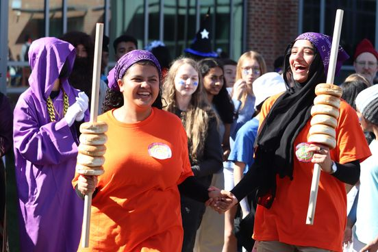 Having just been announced the winners of the group costume contest, seniors Fatima Zahra and Rimena Gebrehiwot run up to the amphitheater to claim their prize. “You just need some basics to put together in the right way,” Zahra said. “I think [our costume] came out good.” 