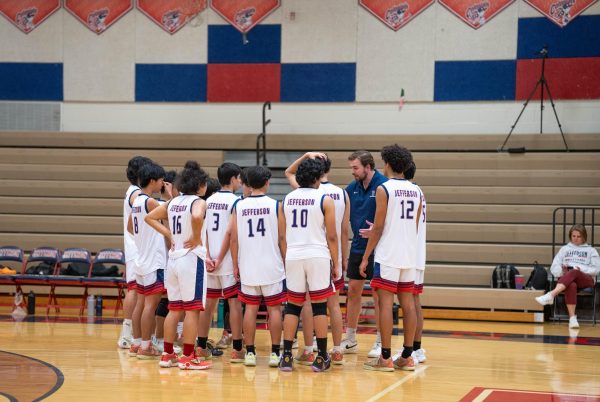 The Jefferson boys volleyball gathers in a team huddle during a timeout in the district finals game. “Eventually, once we started our winning streak, beating every team in our district until the district tournament, my expectations obviously went to winning districts,” junior Nick Boukens said. 