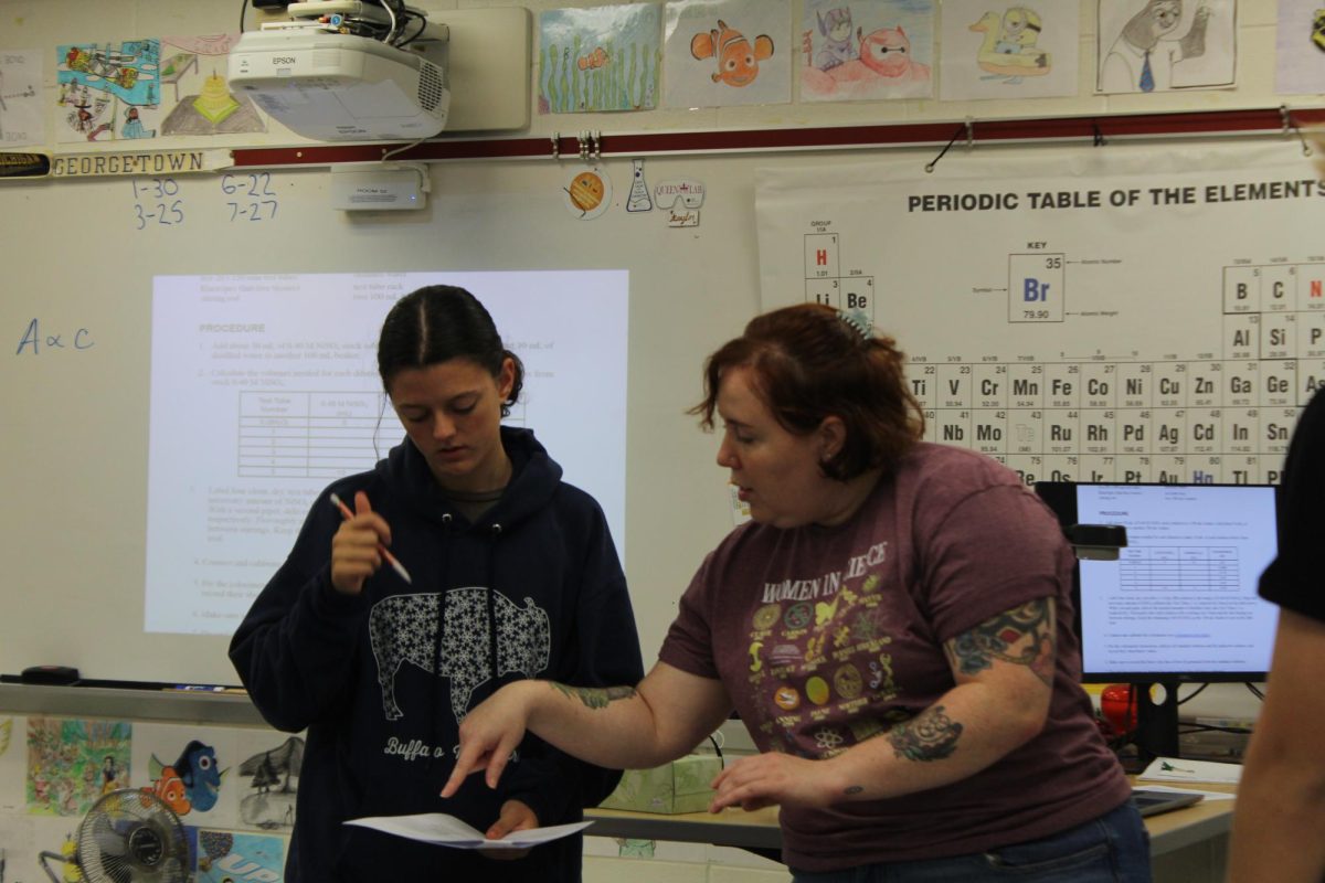 Chemistry teacher Emily Owens instructs a student during fifth period. Owens teaches in room 51 on blue days, one class in room 52 on red days and Organic Chemistry in the Chemical Analysis and Nanochemistry Research Lab. “On my Schoology, I've posted a schedule of where I am during a given period in [the] hope that they can find me if they need me, but it definitely makes me feel a little bit less connected and accessible, which is not what I want, but it's just kind of how it's happened.”