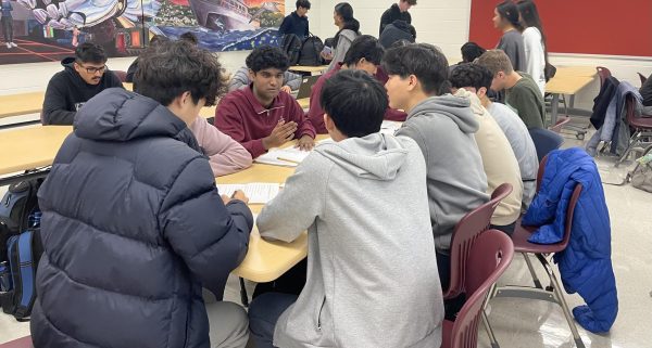 Senior Jason Hao’s group discusses how to solve the math problems for the Jane Street Estimathon, which was hosted on Dec. 4 by the Varsity Math Team (VMT). “I normally go to VMT as my main club,” Hao said. “[The contest] went very well for my team, because we got first [place]. I think it was really fun.” 