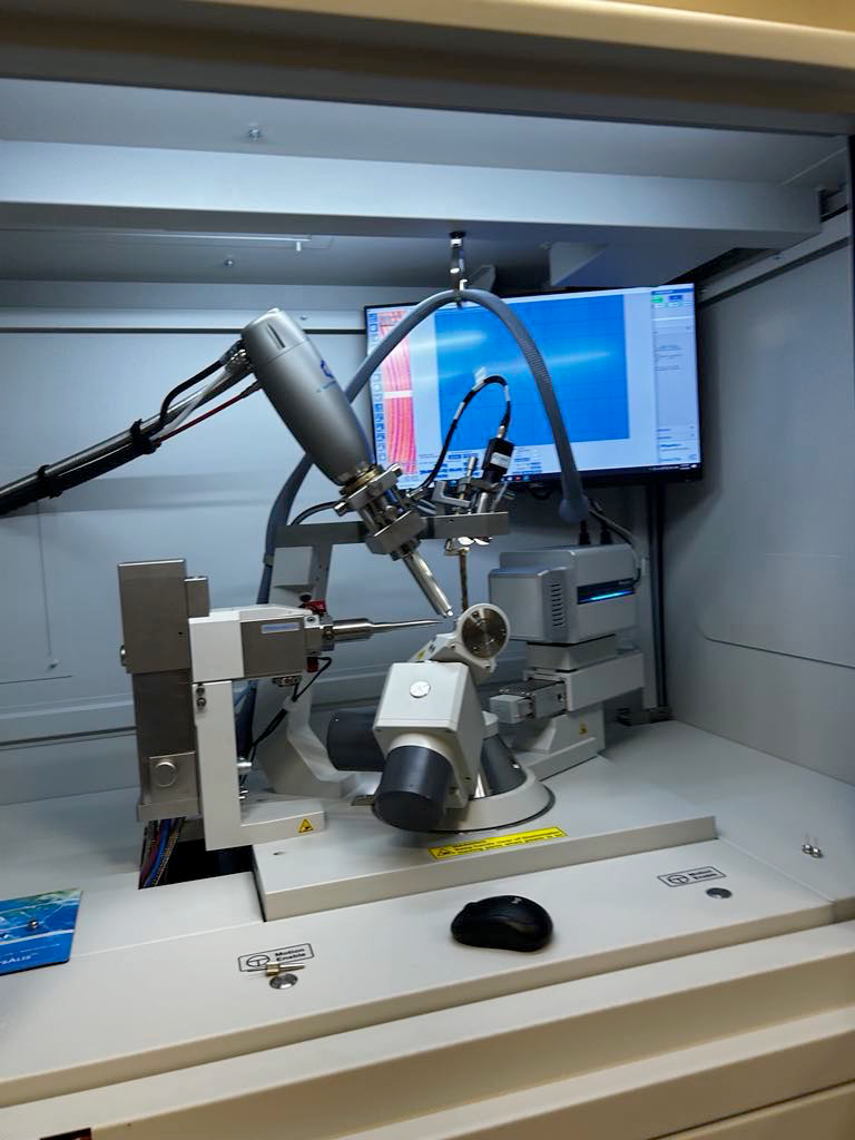 An X-ray diffractometer shoots X-rays at a sample that is hung on the loops at the center of the arms. The X-rays scatter, and a detector picks up all of the patterns. “The sample that’s in there is an organotin crystal, or a tin complex. When selecting a sample for [X-ray diffraction], there [are] a lot of things [to consider] like crystal size and shape. Typically, what we do, is take our synthesized sample of organotin, spread them out on a microscope glass plate, use a solution to keep the crystals steady and [use] a knife to cut down the crystal to fit onto the loop,” senior Jaydon Sun said. 