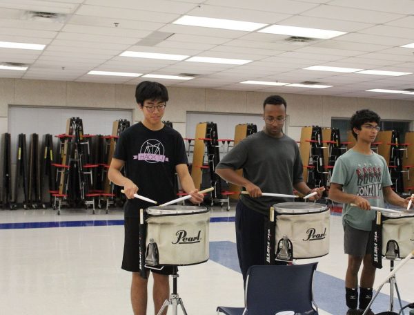 Juniors Isaac Park, Kohlen Farah and sophomore Rudy Balu practice their snare drums during rehearsal. “If someone adjusts their volume, we have to be reactive enough to play with them,” Balu said. “But we also have to be assertive enough that we maintain a sense of cohesiveness in the group.” 